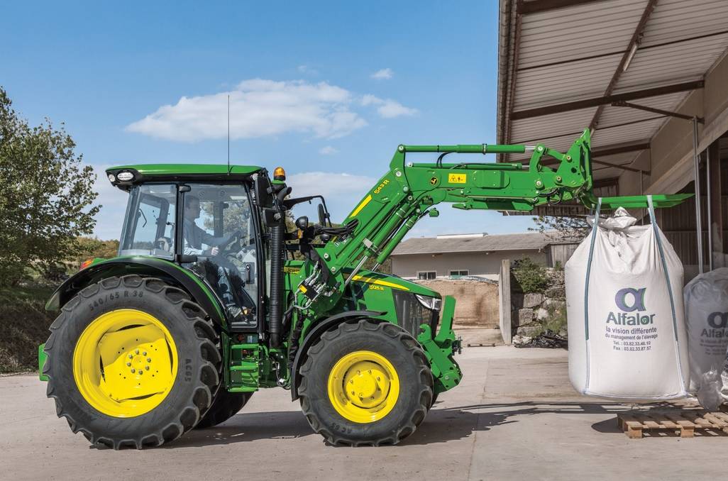 A homlokrakodóval felszerelt John Deere 5R műtrágyapakolás közben.