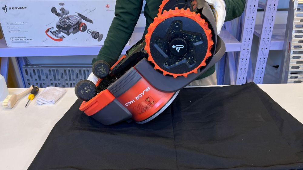 A robotfűnyíró alsó részének előkészítése a tisztításhoz
